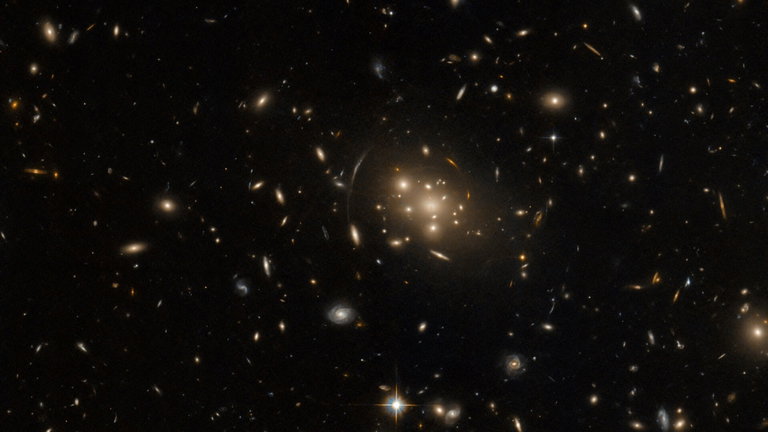 Este cúmulo de galaxias mostrado por el telescopio Hubble de la NASA deforma el espacio-tiempo